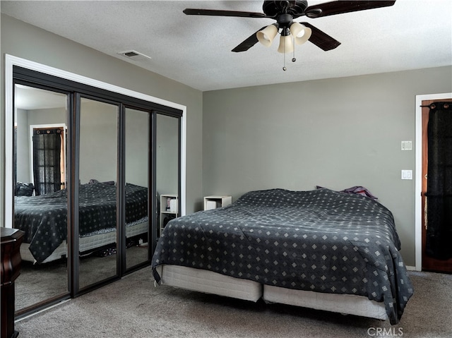 bedroom featuring ceiling fan, carpet flooring, and a textured ceiling