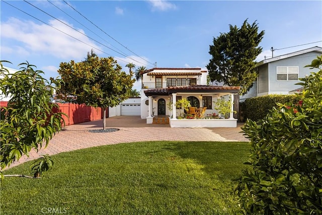 back of property with an outbuilding, a porch, a garage, and a lawn