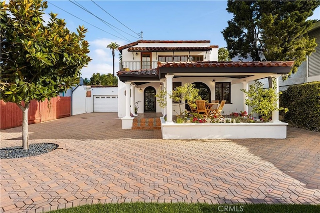 mediterranean / spanish house featuring a balcony and a garage