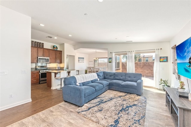 living room with light hardwood / wood-style floors and vaulted ceiling