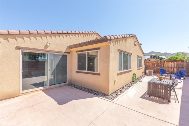 rear view of house featuring central AC unit, a mountain view, an outdoor hangout area, and a patio