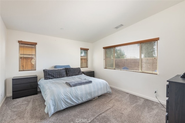 bedroom with light colored carpet and lofted ceiling