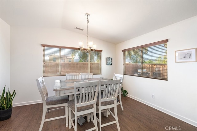 dining area with dark hardwood / wood-style flooring, a chandelier, and lofted ceiling