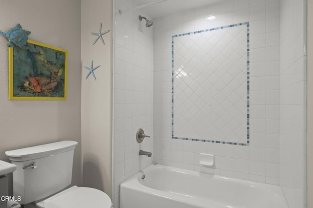 bathroom featuring tiled shower / bath combo and toilet