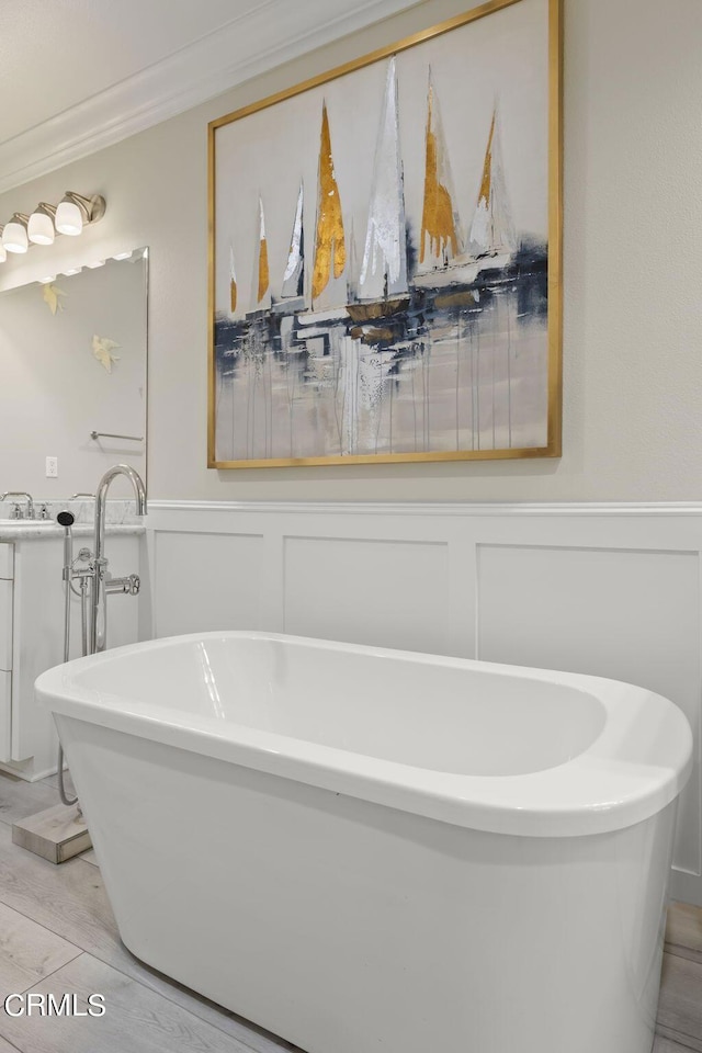 bathroom with a bathtub, ornamental molding, and wood-type flooring