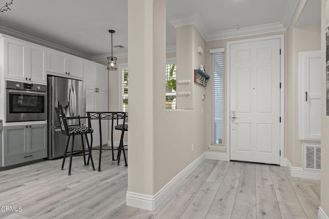 entrance foyer featuring light hardwood / wood-style flooring and crown molding