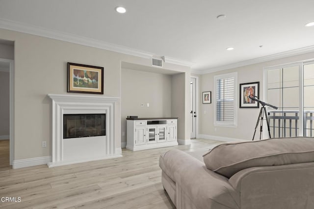 living room with crown molding, plenty of natural light, and light hardwood / wood-style floors