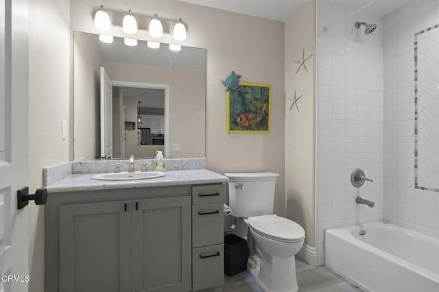 full bathroom featuring vanity, toilet, and tiled shower / bath combo