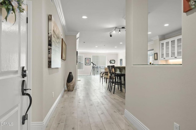 hall featuring ornamental molding and light hardwood / wood-style flooring