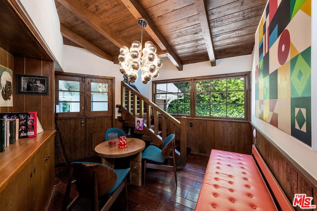 dining area featuring wooden ceiling, vaulted ceiling with beams, dark hardwood / wood-style floors, wood walls, and a chandelier