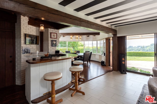 kitchen featuring beamed ceiling and a breakfast bar