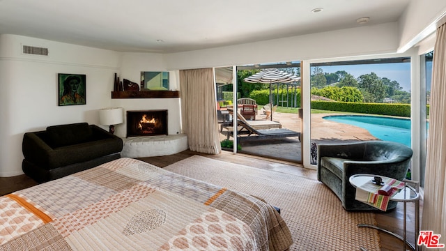 bedroom featuring access to exterior and wood-type flooring