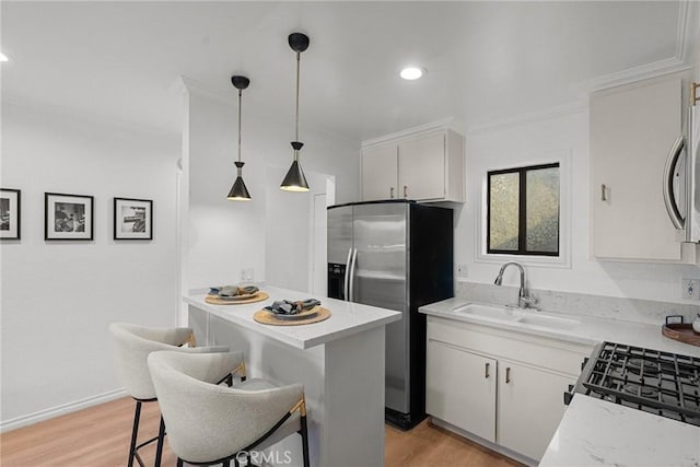 kitchen featuring stainless steel fridge, a kitchen breakfast bar, decorative light fixtures, light hardwood / wood-style flooring, and white cabinetry