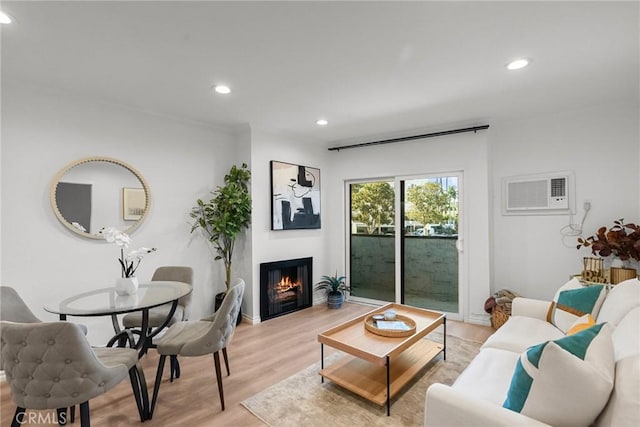 living room with light wood-type flooring and an AC wall unit