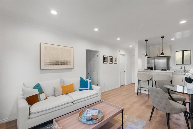 living room with light wood-type flooring and sink