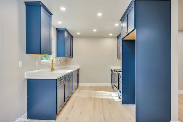 kitchen featuring light wood-type flooring, stainless steel range with electric stovetop, blue cabinetry, and sink