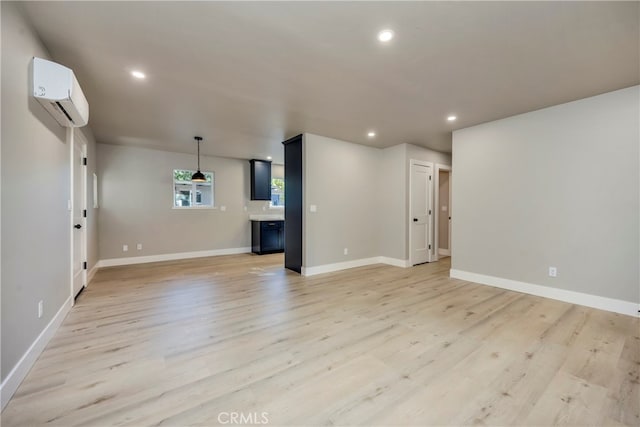 unfurnished living room with light hardwood / wood-style flooring and a wall unit AC