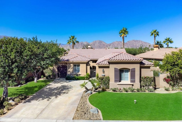 mediterranean / spanish house with a mountain view and a front lawn