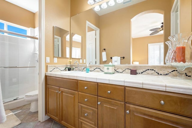 bathroom with plenty of natural light, vanity, toilet, and a shower with shower door