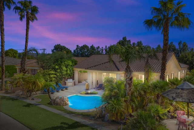 pool at dusk with a patio