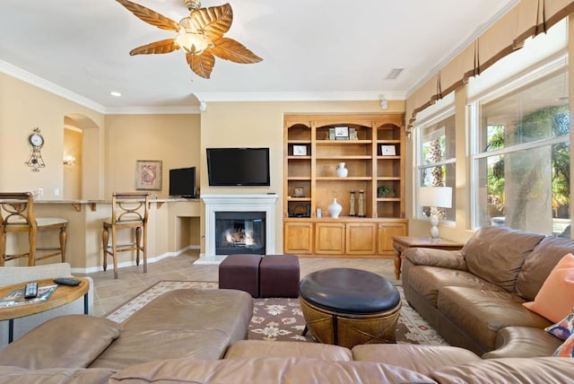 tiled living room with ornamental molding and ceiling fan