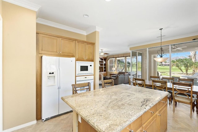 kitchen with white appliances, light stone counters, hanging light fixtures, and a kitchen island