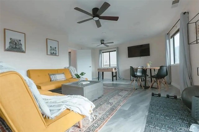 living room featuring concrete floors and ceiling fan