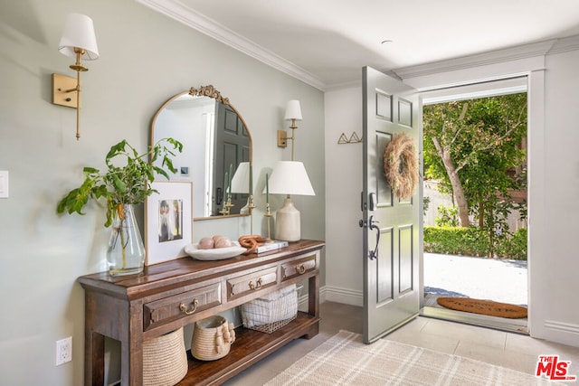 tiled entrance foyer featuring crown molding