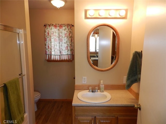 bathroom with vanity, toilet, wood-type flooring, and walk in shower