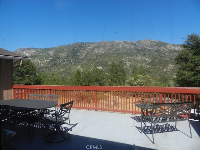 wooden deck with a mountain view and a patio