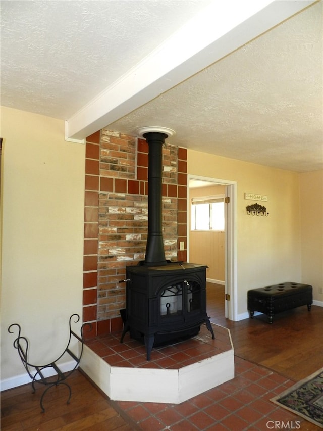 room details with a wood stove, a textured ceiling, and hardwood / wood-style flooring