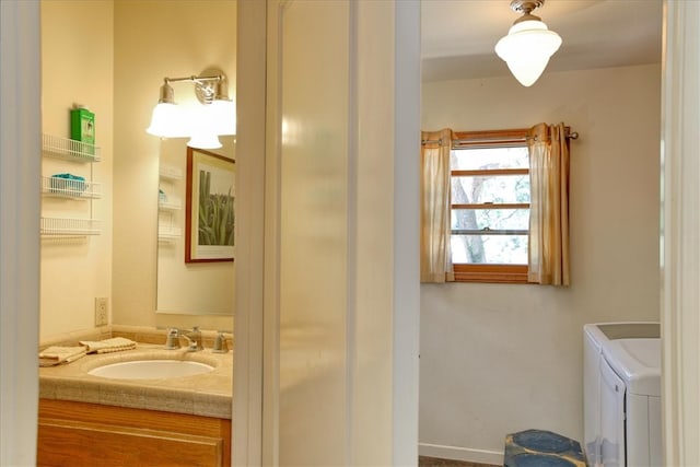 half bathroom featuring washer and dryer and vanity