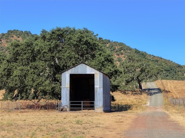 view of outdoor structure featuring a mountain view, an outdoor structure, and a rural view