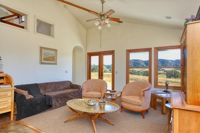 living room featuring arched walkways, french doors, carpet, a ceiling fan, and high vaulted ceiling