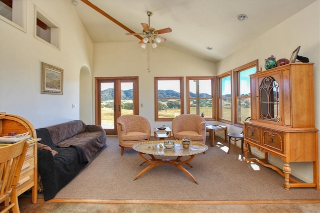 living room featuring arched walkways, high vaulted ceiling, a mountain view, carpet floors, and french doors