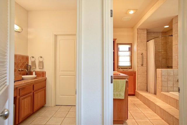 full bathroom featuring a tile shower, tile patterned flooring, and vanity