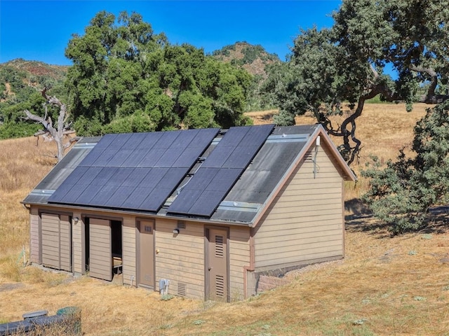 view of outbuilding with a mountain view and solar panels