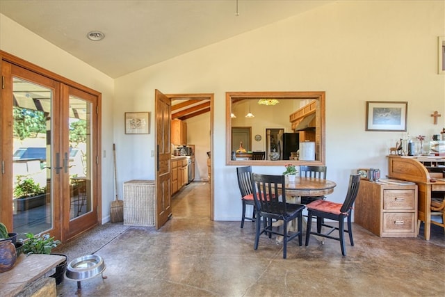 dining area featuring high vaulted ceiling, concrete flooring, and french doors