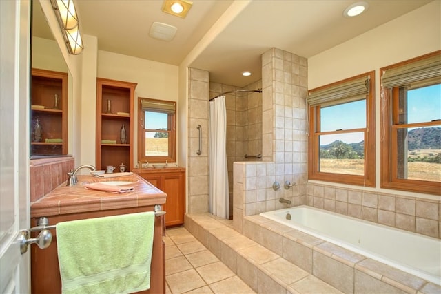 full bathroom featuring double vanity, a relaxing tiled tub, tiled shower, tile patterned floors, and a sink