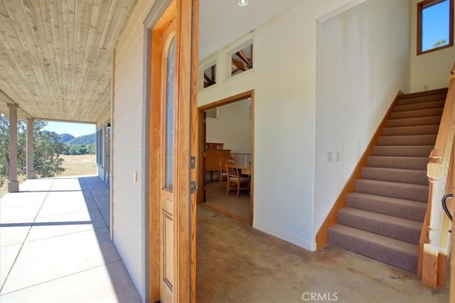 stairs with wooden ceiling and plenty of natural light
