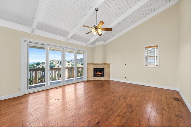 unfurnished living room with wood-type flooring, a fireplace, ceiling fan, beam ceiling, and high vaulted ceiling