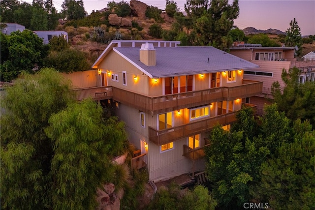 back house at dusk with a balcony