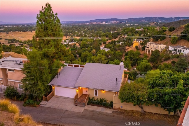 aerial view at dusk featuring a mountain view