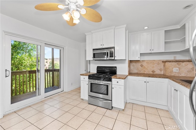 kitchen with backsplash, dark stone counters, white cabinetry, appliances with stainless steel finishes, and ceiling fan