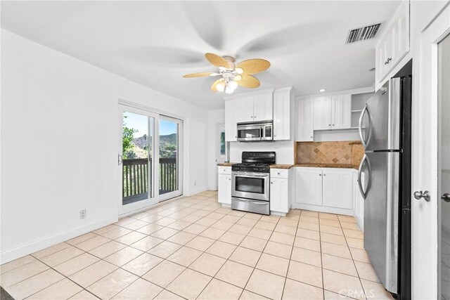 8462 Hillcroft Dr, West Hills, CA 91304 - kitchen featuring appliances with stainless steel finishes, decorative backsplash, light tile patterned floors, and white cabinetry