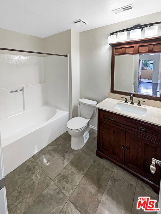 full bathroom featuring tub / shower combination, vanity, and toilet