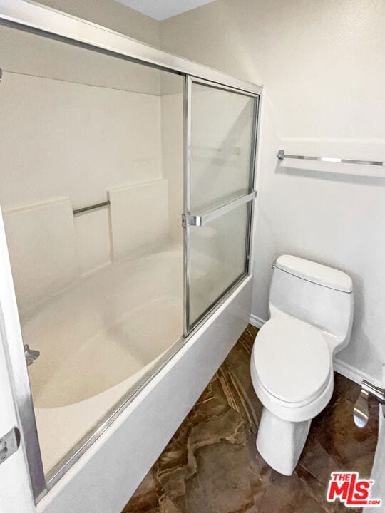 bathroom with enclosed tub / shower combo and toilet