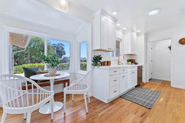 kitchen featuring sink, dishwasher, white cabinets, breakfast area, and light wood-type flooring