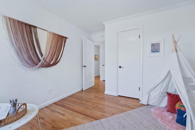 bedroom with crown molding and light hardwood / wood-style floors