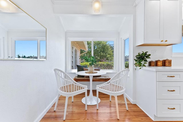 dining room featuring crown molding, breakfast area, and light wood-type flooring